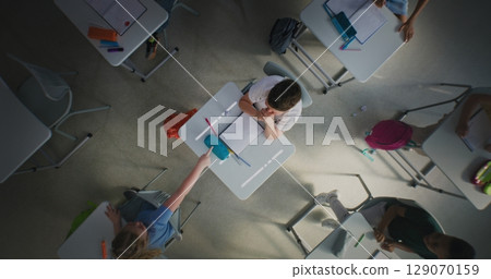Depressed Primary School Boy Sitting at Desk in Classroom While Aggressive Classmates Abusing Him Depressed Primary School Boy Sitting at Desk in Classroom While Aggressive Classmates Abusing Him 129070159