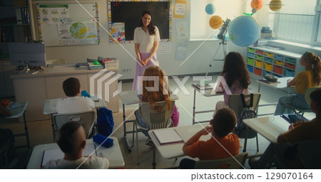 Female Teacher Educating Ecology to Smart Kids. Primary School Children Raising Hands to Give Answer 129070164