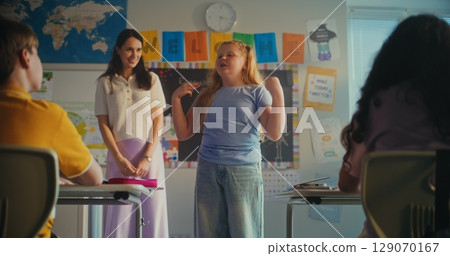 Smart Primary School Girl Showcasing Knowledge of Ecology in Front of Class and Teacher Smart Primary School Girl Showcasing Knowledge of Ecology in Front of Class and Teacher 129070167