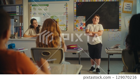 Primary School Boy Showcasing Knowledge of Ecology in Front of Class and Female Teacher 129070216