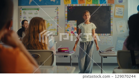 Female Teacher Calling Young Student to the Board. Primary School Girl Showcasing Knowledge of Ecology 129070244