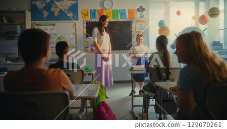 Female Teacher Introducing New Young Student. Group of Diverse Kids Greeting New Classmate 129070261