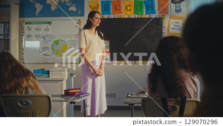 Female Teacher Calling Young Student to the Board. Primary School Girl Showcasing Knowledge of Ecology 129070296