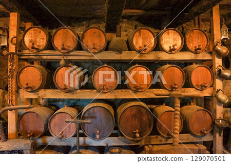A dimly lit warehouse with many barrels on shelves 129070501