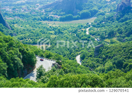 一輛汽車沿著山路行駛，從一座小山頂欣賞大自然 129070541