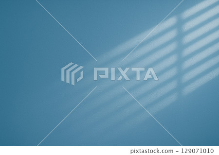 A simple blue background with the shadow of the blinds 129071010