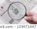 Newspaper viewed through a magnifying glass 129071447