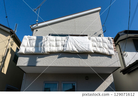 Hanging futons on the railing of the balcony 129071612