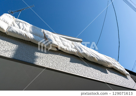 Hanging futons on the railing of the balcony 129071613