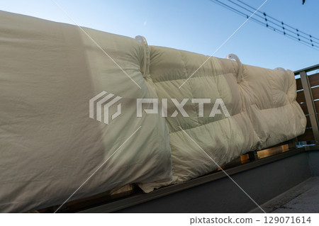 Hanging futons on the railing of the balcony 129071614