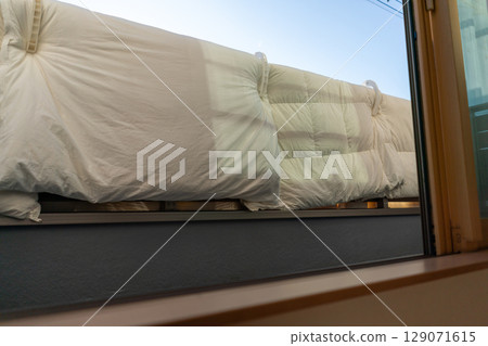 Hanging futons on the railing of the balcony 129071615