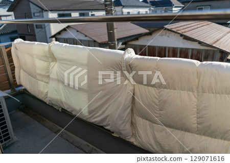 Hanging futons on the railing of the balcony 129071616