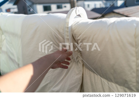 Hanging futons on the railing of the balcony 129071619