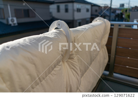 Hanging futons on the railing of the balcony 129071622