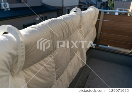 Hanging futons on the railing of the balcony 129071623