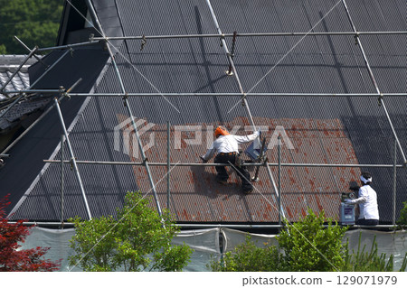 Construction site: Renovation of an old house: Roof painting work 129071979