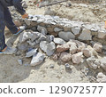 man cleaning the stone wall for construction 129072577