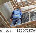 construction worker installing insulation of house 129072579