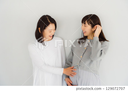 一位幸福的母親和她即將結束懷孕的女兒 一位幸福的母親和她即將結束懷孕的女兒 129072707