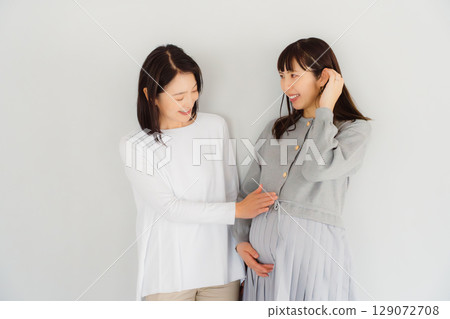 A happy mother and her daughter nearing the end of her pregnancy 129072708