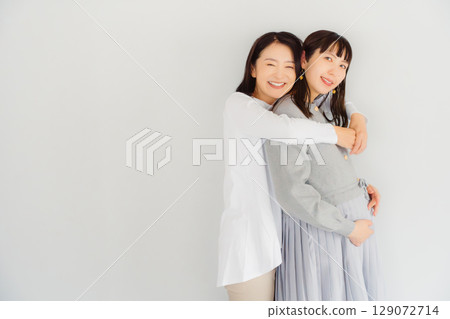 一位幸福的母親和她即將結束懷孕的女兒 一位幸福的母親和她即將結束懷孕的女兒 129072714