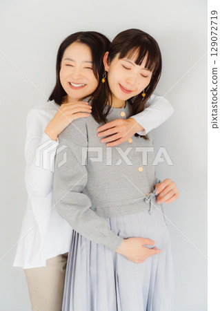 A happy mother and her daughter nearing the end of her pregnancy 129072719