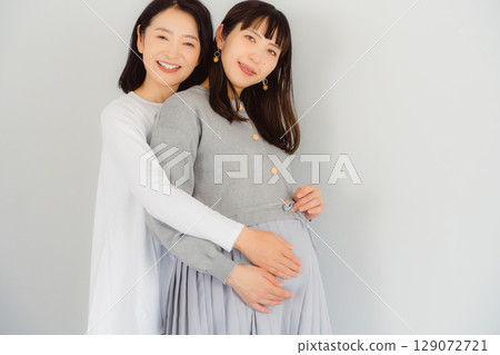 A happy mother and her daughter nearing the end of her pregnancy A happy mother and her daughter nearing the end of her pregnancy 129072721