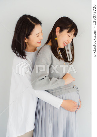 A happy mother and her daughter nearing the end of her pregnancy 129072726