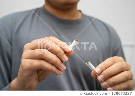 Quit smoking, Asian teenage man breaking destroy cigarette in hand. 129073227