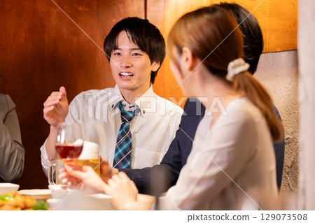 Drinking party: Men and women drinking at an izakaya 129073508