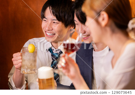 Drinking party: Men and women drinking at an izakaya 129073645