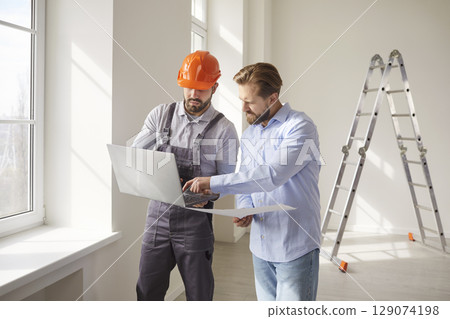 Foreman worker holding laptop and giving consultancy to man 129074198
