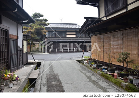 Spring in Gifu Prefecture, Japan: Old streets in the center of Takayama city, historic Japanese houses and beautiful potted plants on the roadside 129074568
