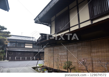 Spring in Gifu Prefecture, Japan: Old streets in the center of Takayama city, historic Japanese houses and beautiful potted plants on the roadside 129074572