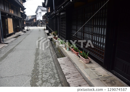 Spring in Gifu Prefecture, Japan: Old streets in the center of Takayama city, historic Japanese houses and beautiful potted plants on the roadside 129074587