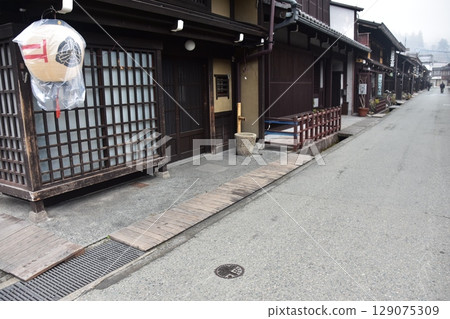 日本岐阜縣高山市上三之町的古老街景。歷史悠久的老房子和裝飾燈籠。高山春節期間的清晨景象。 日本岐阜縣高山市上三之町的古老街景。歷史悠久的老房子和裝飾燈籠。高山春節期間的清晨景象。 129075309