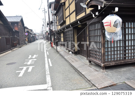 The old townscape of Kamisannomachi in Takayama City, Gifu Prefecture, Japan. Historic old houses and decorative lanterns. A morning scene during the Takayama Spring Festival. 129075319