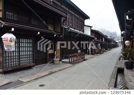 日本岐阜縣高山市上三之町的古老街景。歷史悠久的老房子和裝飾燈籠。高山春節期間的清晨景象。 129075346