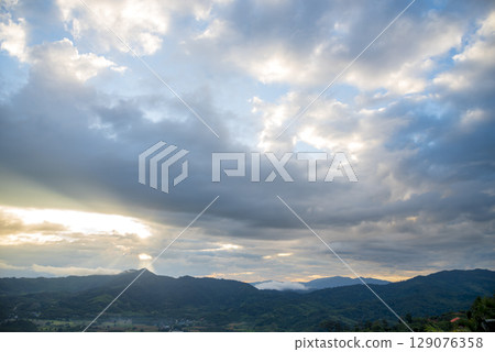 Scenic view dramatic beautiful sunset sky. Natural Sunset Sunrise on meadow silhouette shadow dark land. Vibrant dramatic sky on sunset, dawn, sunrise in Countryside. Landscape Colorful Sky At Sunset 129076358