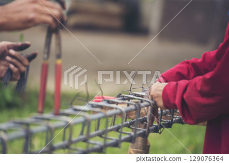 Construction Men hands bending cutting steel wire fences bar reinforcement of concrete work. Worker hands using pincer pliers iron wire. Outdoor Worker using wire bending pliers, construction work Construction Men hands bending cutting steel wire fences bar reinforcement of concrete work. Worker hands using pincer pliers iron wire. Outdoor Worker using wire bending pliers, construction work 129076364
