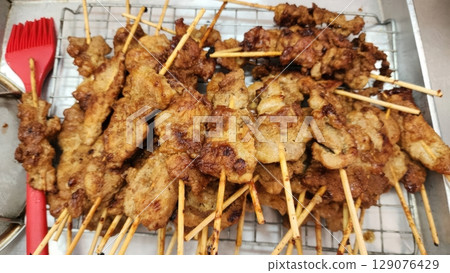 Grilled Pork Satay Skewers on a Metal Rack 129076429