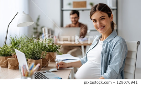 Happy pregnant mom working remotely on laptop. Online video call. The happy pregnant woman participates in an online meeting, showcasing her vibrant personality. 129076941