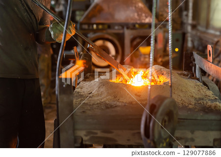 Ferrous metal billet is melted in an induction furnace closeup Ferrous metal billet is melted in an induction furnace closeup 129077886