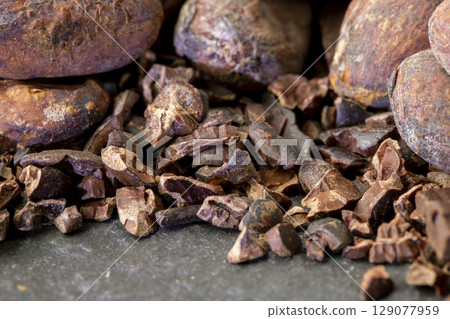 Close-up of Natural cocoa powder with brown cocoa beans and dry cacao pod  on a vintage wooden table. 129077959