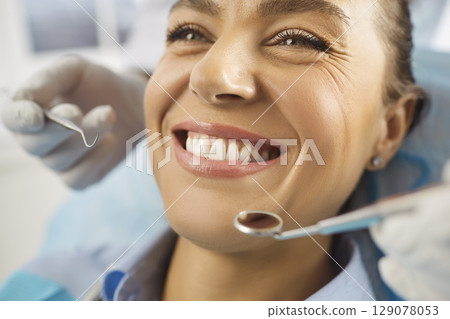 Close up shot of cheerful young woman being on dentist visit, undergoing dental treatment 129078053