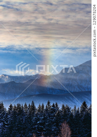 Mysterious light appears in the winter mountain landscape 129078204
