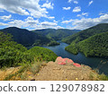 View from Piatra lui Lucaci over the Tarnita lake and forest mountains on a beautiful summer day with blue sky and white clouds. Cluj, Romania 129078982