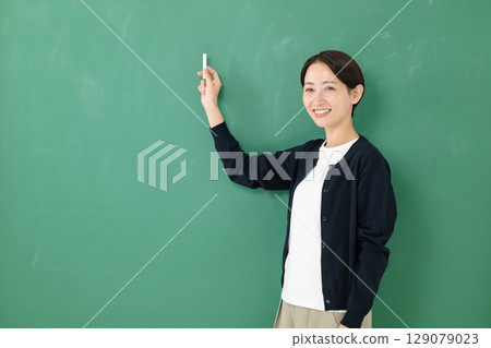 A woman standing in front of a blackboard 129079023