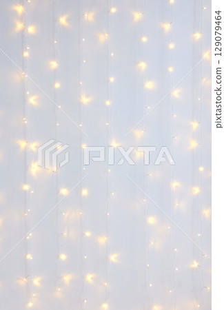 Bright white string lights creating a warm and festive atmosphere against plain 129079464