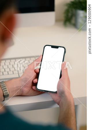 Close up of person holding smartphone with white screen for app or website mockup 129080904